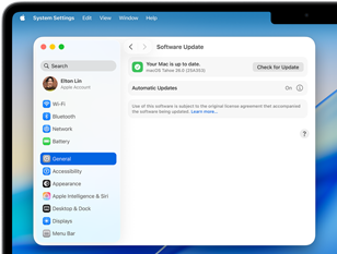 Una ventana de Configuración del Sistema muestra el mensaje 'Tu Mac está actualizada' con macOS Tahoe 26.0 en una MacBook Pro de 14 pulgadas