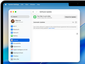 Una ventana de Configuración del Sistema muestra el mensaje 'Tu Mac está actualizada' con macOS Tahoe 26.0 en una MacBook Pro de 14 pulgadas