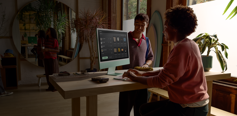 Una persona del equipo de ventas procesa fácilmente la transacción de un cliente en una iMac de 24 pulgadas verde
