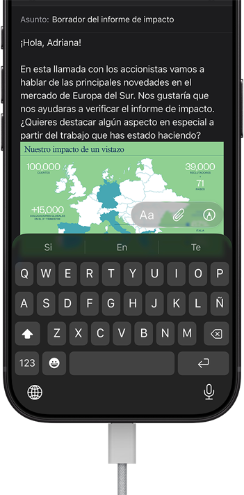 iPhone 18 Pro, negro, conectado a un cargador, la pantalla muestra un email de trabajo en Mail